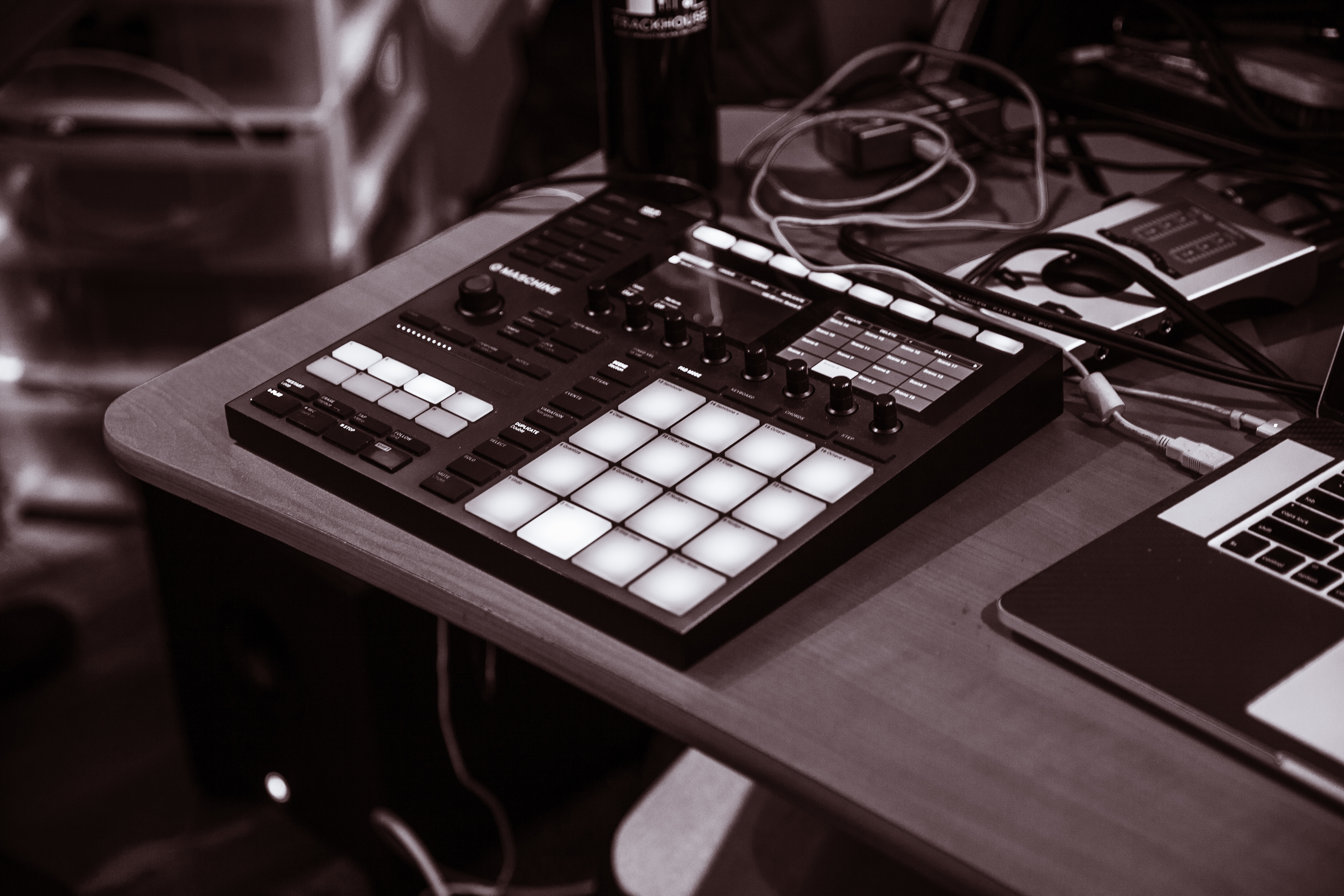 Grayscale shot of a drum pad machine for beats and sound design on a wooden table